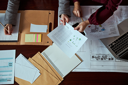 Organizing papers for a CMMC compliance audit.